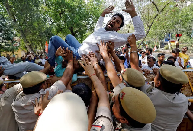 An activist of Delhi Pradesh Youth Congress shouts slogans as police try to stop him cross a barricade during a protest against what the activists say are politically motivated raids by Income Tax officials, in New Delhi, India, April 10, 2019. (Photo by Anushree Fadnavis/Reuters)
