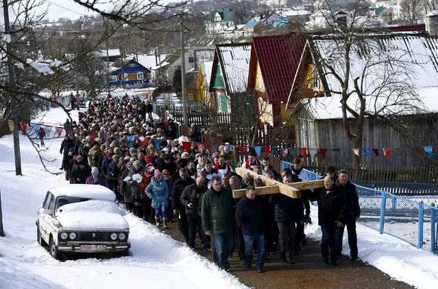 Belarussian Catholics carry a wooden cross as they take part in a procession celebrating Palm Sunday in the town of Oshmiany, Belarus, March 20, 2016. (Photo by Vasily Fedosenko/Reuters)