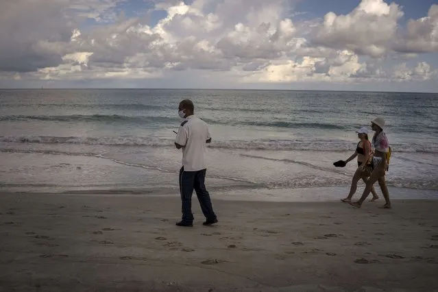 A security employee checks the beach while tourists walk on the beach of the Iberostar Selection Varadero hotel in Varadero, Cuba, Wednesday, September 29, 2021. (Photo by Ramon Espinosa/AP Photo)