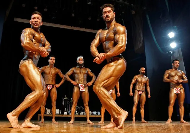 Participants flex their muscles during the “Mr. Kashmir” bodybuilding competition in Srinagar on November 14, 2021. (Photo by Danish Ismail/Reuters)