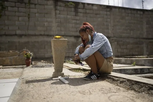 Gineth Gil visits the tomb of her 9-year-old daughter Jeannys Herrera at the South in Caracas, Venezuela, Thursday, November 11, 2021. The 9-year-old died three months ago after about two years of waiting for a kidney transplant. (Photo by Ariana Cubillos/AP Photo)