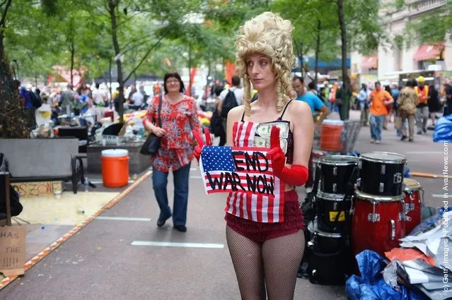 A woman holds an anti-war sign in a park where those affiliated with the Occupy Wall Street demonstrations