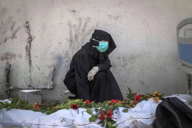 A woman mourns by a body unearthed at Nasser Hospital in Khan Yunis in the southern Gaza Strip on April 23, 2024 amid the ongoing conflict between Israel and the Palestinian militant group Hamas. (Photo by AFP Photo/Stringer)