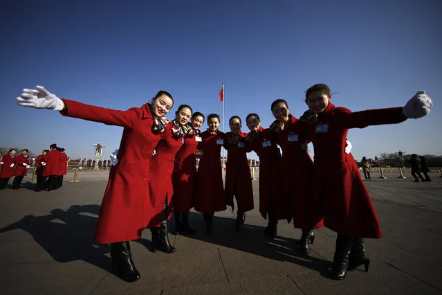 In this Sunday, March 5, 2017 photo, hospitality staff pose for photographs on Tiananmen Square during the National People's Congress held at the Great Hall of the People in Beijing. (Photo by Andy Wong/AP Photo)