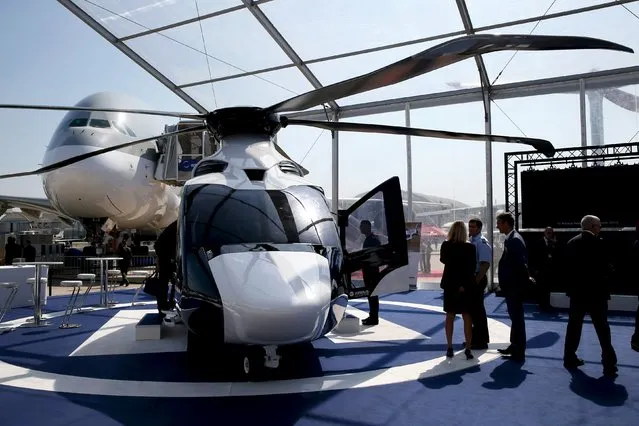 Visitors look at a H160 of Airbus Helicopters on display during the 51st Paris Air Show at Le Bourget airport near Paris June 17, 2015. REUTERS/Pascal Rossignol 