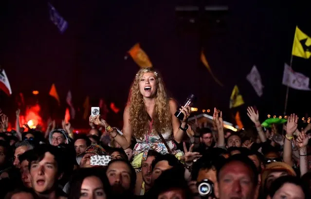 Revellers dance as they listen to Florence and the Machine perform on the Pyramid Stage at Worthy Farm in Somerset during the Glastonbury Festival in Britain, June 26, 2015. (Photo by Dylan Martinez/Reuters)