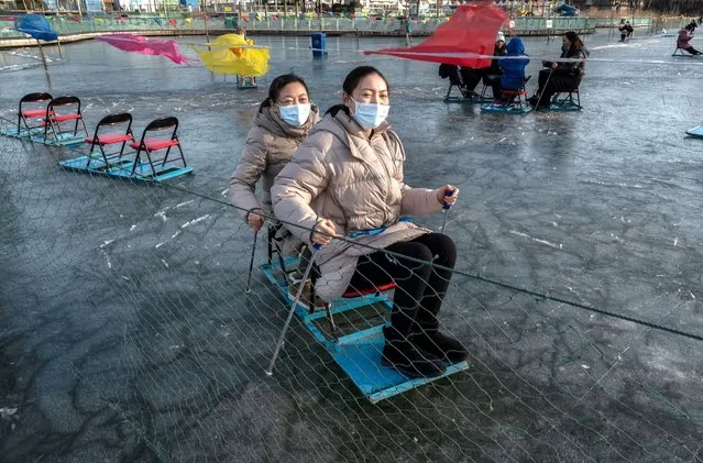 Women ride on an ice chair at a local park on January 8, 2022 in Beijing, China. (Photo by Kevin Frayer/Getty Images)