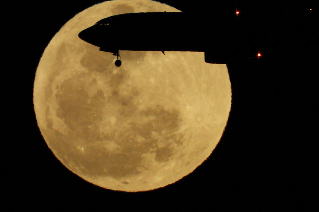 A plane crosses the full moon known as the “Pink Moon” over the island of Gran Canaria, Spain, on April 23, 2024. (Photo by Borja Suarez/Reuters)