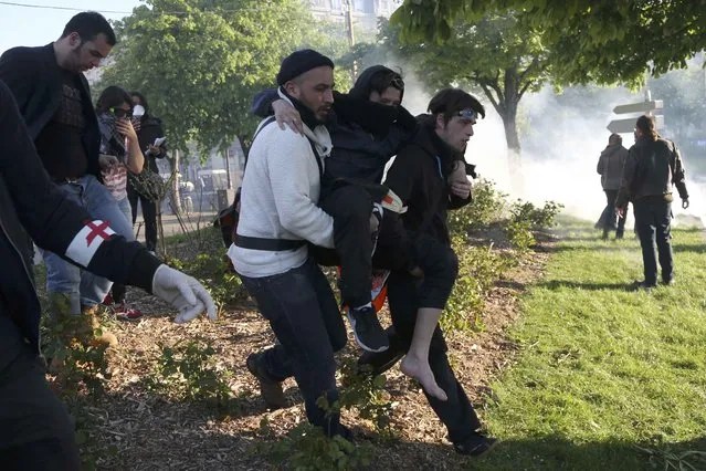An injured demonstrator is evacuated at the Place de la Nation as French CRS riot police advance at the end of a protest against the French labour law proposal during the May Day labour union march in Paris, France, May 1, 2016. (Photo by Charles Platiau/Reuters)