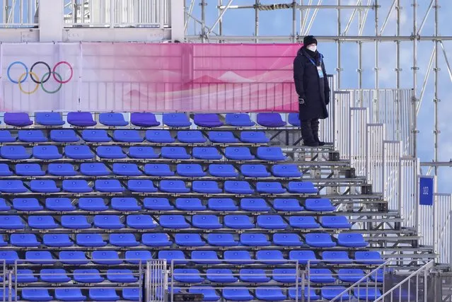 A member of security stands in the empty stands in the finish area ahead of the men's downhill at the 2022 Winter Olympics, Sunday, February 6, 2022, in the Yanqing district of Beijing. (Photo by Dmitri Lovetsky/AP Photo)