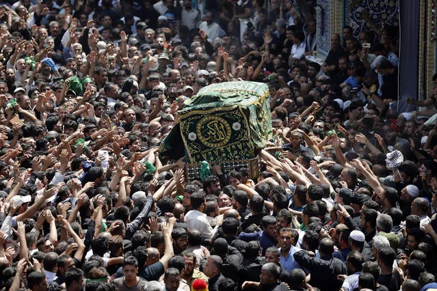 Shiite pilgrims carry a symbolic coffin at the holy Muslim Shiite shrine of Imam Moussa al-Kadhim as pilgrims gather to commemorate his death at the northern neighborhood of Kadhimiyah in Baghdad, Iraq, Tuesday, May 3, 2016. Tens of thousands of Shiite pilgrims converged Tuesday on a golden-domed Shiite shrine in Baghdad to commemorate the anniversary of the death of a revered imam as authorities tightened security measures in the Iraqi capital amid concerns of more attacks by Sunni extremists. (Photo by AP Photo)