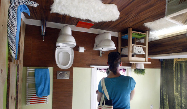 A woman stands inside the bathroom of a house, which was built upside down by Polish architects Irek Glowacki and Marek Rozhanski, in the western Austrian village of Terfens May 5, 2012. (Photo by Dominic Ebenbichler/Reuters)