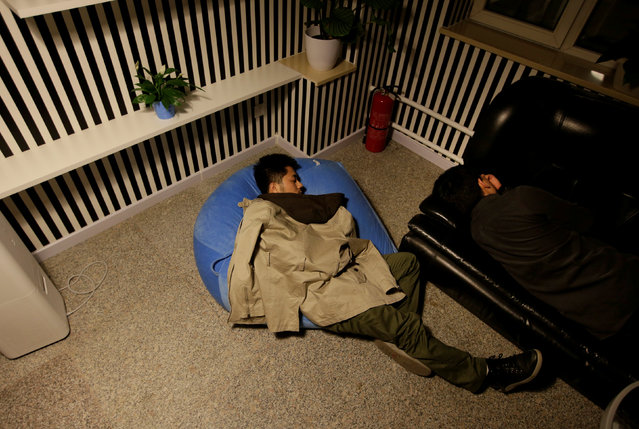 Yu Xiaojian (L) and Li Yan, employees at Goopal Group, take a nap during a break at work around midnight, in Beijing, China, April 19, 2016. (Photo by Jason Lee/Reuters)