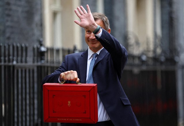 Britain's Chancellor of the Exchequer Jeremy Hunt gestures as he poses with the budget box at Downing Street in London, Britain on March 15, 2023. (Photo by Hannah McKay/Reuters)