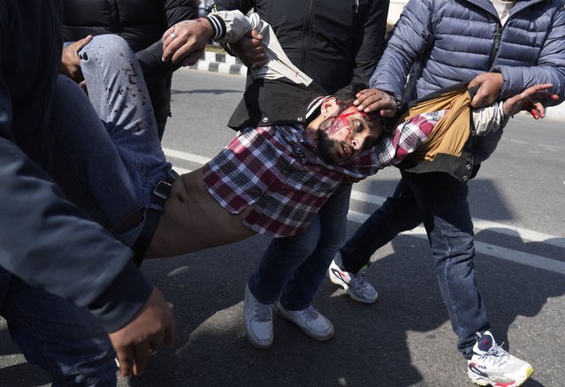 A injured protester is taken to hospital as protesters opposing a proposed U.S. half billion dollars grant for Nepal clash with police as the parliament debates the contentious aid in Kathmandu, Nepal, Sunday, February 20, 2022. (Photo by Niranjan Shreshta/AP Photo)