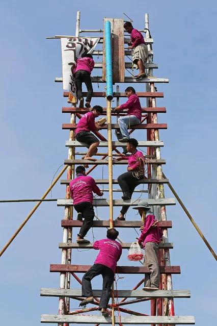 A rocket building team climbs the scaffolding and prepares to launch their rocket at the Bun Bang Fai festival on May 11, 2014 in Yasothon, Thailand. During the Bun Bang Fai rocket festival, Thai residents launch enormous home-made rockets into the air to gain Buddhist merit and to celebrate the beginning of the rainy season. (Photo by Taylor Weidman/Getty Images)