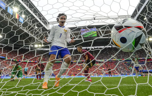 Antoine Griezmann of France celebrates in the Belgium goal after Randal Kolo Muani of France, shot at goal to cause Belgium's Jan Vertonghen to score an own goal during a round of sixteen match between France and Belgium at the Euro 2024 soccer tournament in Duesseldorf, Germany, Monday, July 1, 2024. (Photo by Martin Meissner/AP Photo)