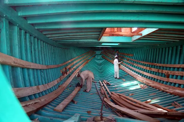 Pakistani craftsmen build a boat at the Karachi Shipyard in the southern port city of Karachi, Pakistan, 17 February 2022. The Karachi Shipyard is strategically located on the cross roads of South Asia and Gulf region. The shipyard carries out shipbuilding and ship repairs for local and foreign customers. (Photo by Rehan Khan/EPA/EFE)