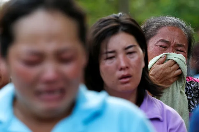 Women who lost their relatives cry near a burnt building at the Pitakiatwittaya School in the northern province of Chiang Rai, Thailand, May 23, 2016. (Photo by Athit Perawongmetha/Reuters)