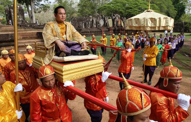 Cambodian officers carry Khim Bun Song (top), Governor of Siem Reap province during the Royal Ploughing Ceremony procession near Bayon temple in Siem Reap province, Cambodia, 24 May 2016. The Royal Ploughing Ceremony is celebrated to predict the upcoming distribution of rainfall and agricultural harvesting in the country through the oxen's appetite of paddy, corn, beans, grass, sesame, water or wine. (Photo by Mak Remissa/EPA)