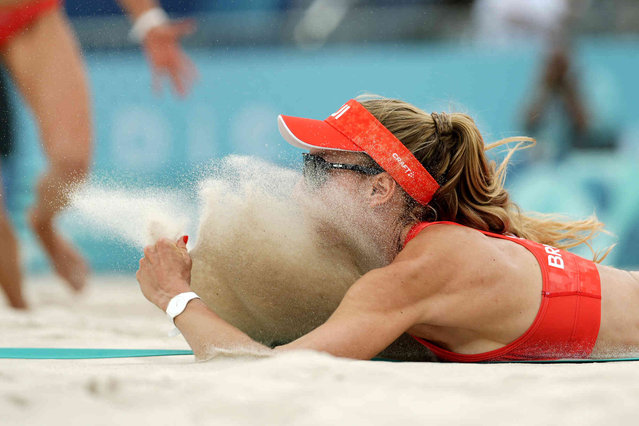 Switzerland's Nina Brunner lands in the sand after diving for a shot in a beach volleyball match against France at the 2024 Summer Olympics, Saturday, August 3, 2024, in Paris, France. (Photo by Robert F. Bukaty/AP Photo)