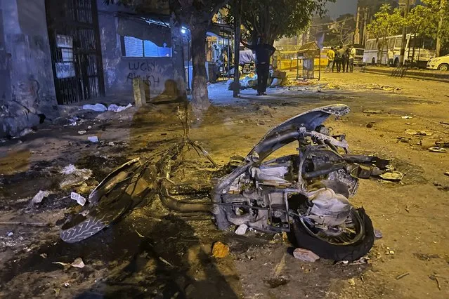 Burnt remains of a motorcycle lie in a street after communal violence in New Delhi, India, Sunday, April 17, 2022. Police in India's capital have arrested 14 people after communal violence broke out during a Hindu religious procession, leaving several injured. The suspects were arrested on charges of rioting and criminal conspiracy, among others, according to local media reports Sunday. (Photo by Arbab Ali/AP Photo)