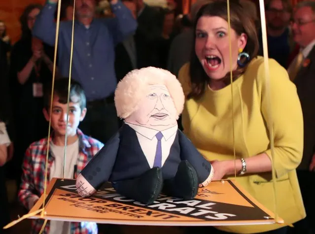 Britain's Liberal Democrats leader Jo Swinson reacts next to a puppet depicting British Prime Minister Boris Johnson as she plays a game during a general election campaign event in Edinburgh, Scotland, Britain on December 5, 2019. (Photo by Russell Cheyne/Reuters)