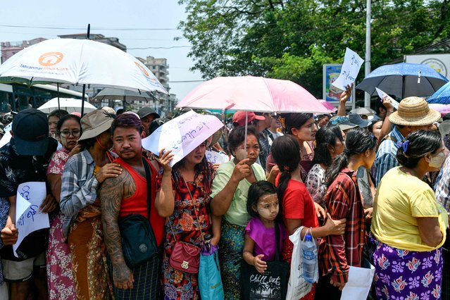 Relatives gather around a bus carrying prisoners being released from Insein prison for the Buddhist New Year, in Yangon on April 17, 2024. Myanmar's junta on April 17, 2024, announced a pardon for more than 3,300 prisoners under a regular amnesty to mark the country's traditional new year festival. (Photo by AFP Photo)