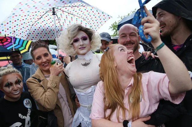 Supporters of gay rights gathered outside the Chancellery celebrate following a vote at the nearby Bundestag in which parliamentarians approved a new law legalizing gay marriage in Germany on June 30, 2017 in Berlin, Germany. In a historic vote following emotional statements by parliamentarians both for and against the issue Germany is transferring homosexual relationships from a privileged partnership to marriage with the same rights as marriage between heterosexual couples. (Photo by Sean Gallup/Getty Images)