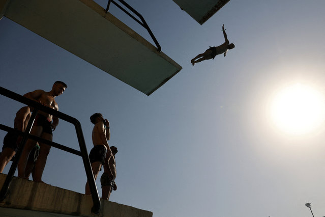 An Iranian man jumps into a pool during the heat surge in Tehran, Iran on July 22, 2024. (Photo by Majid Asgaripour/WANA via Reuters)