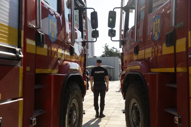 A Romanian firefighter stands in front of a fire engine during a ceremony, in Athens, on Saturday, July 2, 2022. Twenty eight Romanian firefighters, the first of more than 200 firefighters from other European countries that will help their Greek colleagues in fighting wildfires, were welcomed by Climate Crisis and Civil Protection Minister Christos Stylianides and the leadership of Greece's Fire Service. (Photo by Yorgos Karahalis/AP Photo)