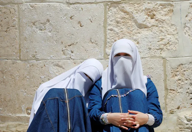 Palestinian women sit by a wall of The Dome of Rock on the compound known to Muslims as Noble Sanctuary and to Jews as Temple Mount in Jerusalem's Old City, before prayers on the last Friday of the holy month of Ramadan July 1, 2016. (Photo by Ammar Awad/Reuters)