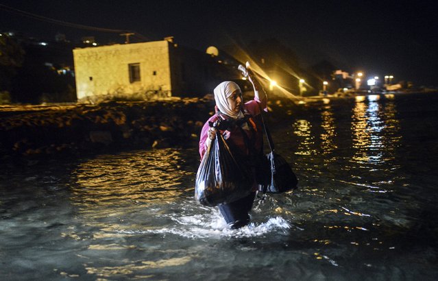 A migrant walks to a boat to reach the Greek island of Kos on early August 18, 2015 off the shore of Bodrum, southwest Turkey. Authorities on the island of Kos have been so overwhelmed that the government sent a ferry to serve as a temporary centre to issue travel documents to Syrian refugees – among some 7,000 migrants stranded on the island of about 30,000 people. (Photo by Bulent Kilic/AFP Photo)