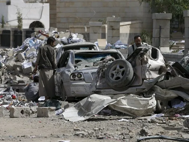 People check the wreckage of cars destroyed by Saudi-led air strikes on the nearby offices of the education ministry's workers union in Yemen's northwestern city of Amran August 19, 2015. (Photo by Khaled Abdullah/Reuters)