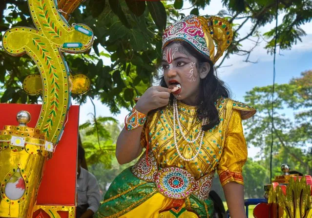 An artist dressed as Hindu Lord Krishna eating Ice cream as she waits to perform on the last day of the week-long celebration of Lord Jagannath's “Rath Yatra”, or the chariot procession, in Kolkata on July 9, 2022. (Photo by Sudipta Das/Pacific Press/Rex Features/Shutterstock)
