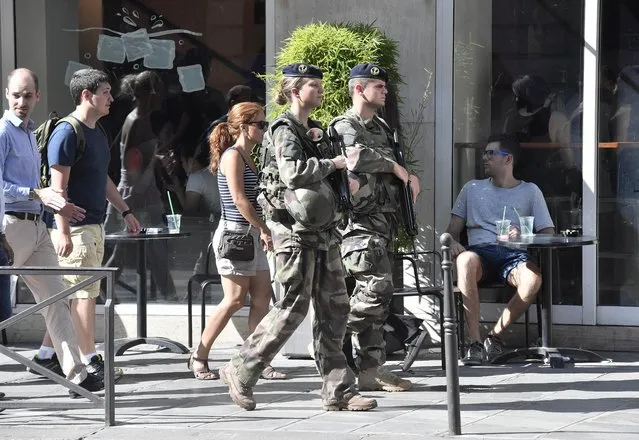 French soldiers patrol in the streets of Paris Saturday July 9, 2016. French police and troops are gearing up for their biggest security challenge since the deadly Nov. 13 attacks across Paris last year, as hundreds of thousands of fans mass in the French capital for Sunday's Euro 2016 European Soccer Championship final. (Photo by Martin Meissner/AP Photo)