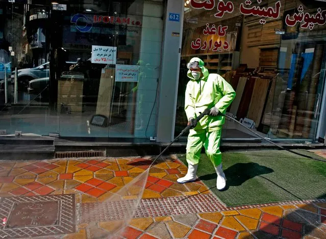 Iranian fire fighters and municipality workers disinfect a street in the capital Tehran for corona virus COVID-19 on March 5, 2020. Iran today reported 15 new deaths from the novel coronavirus and 591 fresh cases in the past 24 hours, bringing the toll to 107 dead and 3,513 infected. (Photo by AFP Photo/Stringer)