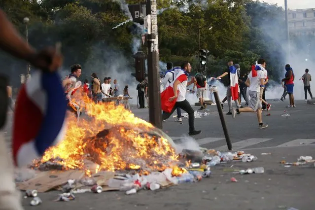 Garbage burns during clashes near the Paris fan zone during the Portugal v France EURO 2016 final soccer match, in Paris, France, July 10, 2016. French police fired tear gas to disperse dozens of people trying to enter the “fan zone” at the foot of the Eiffel Tower to watch the final of the Euro 2016 soccer tournament on Sunday evening, to prevent overcrowding. (Photo by Stephane Mahe/Reuters)