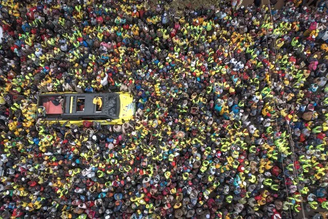 This aerial view shows Kenya's Deputy President and presidential candidate William Ruto of Kenya Kwanza (One Kenya) political party coalition speaking to supporters from a car during his rally in Thika, Kenya, on August 3, 2022. (Photo by Yasuyoshi Chiba/AFP Photo)