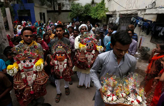 Hindu devotees hold the idols of lord Jagannath along with others during the Rath Yatra, or chariot procession in Karachi, Pakistan,July 17, 2016. (Photo by Akhtar Soomro/Reuters)