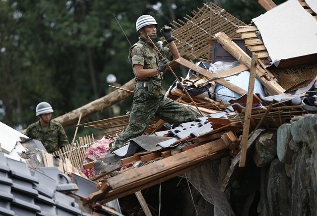 Japan Self-Defense Force (JSDF) soldiers search for survivors at a site where a landslide swept through a residential area at Asaminami ward in Hiroshima, western Japan, August 20, 2014. At least 36 people, including several children, were killed in Japan on Wednesday, when landslides triggered by torrential rain slammed into the outskirts of the western city of Hiroshima, and the toll could rise further, police said. (Photo by Toru Hanai/Reuters)