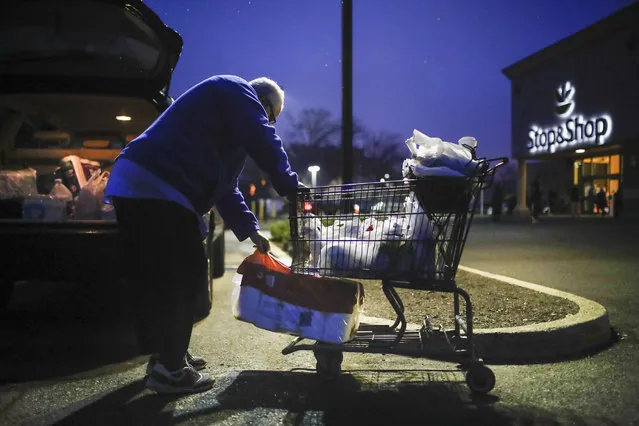 Customer Joseph Nathan loads toilet paper into the trunk of his car after shopping at a Stop & Shop supermarket that opened special morning hours to serve people 60-years and older due to coronavirus concerns, Friday, March 20, 2020, in Teaneck, N.J. (Photo by John Minchillo/AP Photo)
