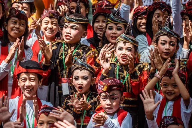 Indonesian students take part in a flashmob and perform the Remo dance at the zoo in Surabaya on August 21, 2022. (Photo by Juni Kriswanto/AFP Photo)