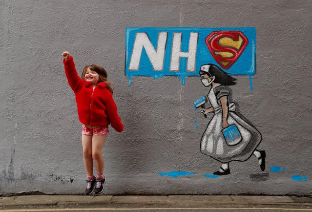 Lilly Davenport poses for her dad infront of a mural in tribute to the NHS painted by artist Rachel List on the wall of the Horse Vaults pub in Pontefract, as the spread of the coronavirus disease (COVID-19) continues, Pontefract, Britain, April 4, 2020. (Photo by Lee Smith/Reuters)