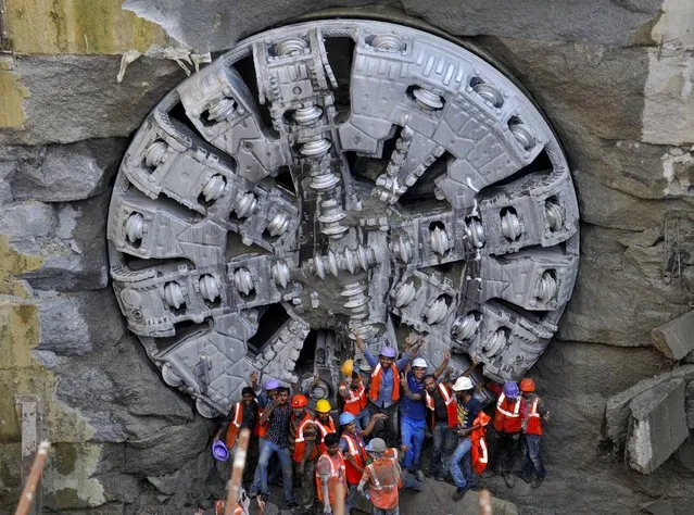 Metro construction workers celebrate in front of a Tunnel Boring Machine (TBM) breakthrough point after successfully building a tunnel for the metro train in Bengaluru, India, August 31, 2015. India's economic growth slowed by more than expected in the quarter to June, according to data released on Monday that will worry Prime Minister Narendra Modi and prompt more urgent calls from his aides for interest rate cuts. (Photo by Abhishek N. Chinnappa/Reuters)