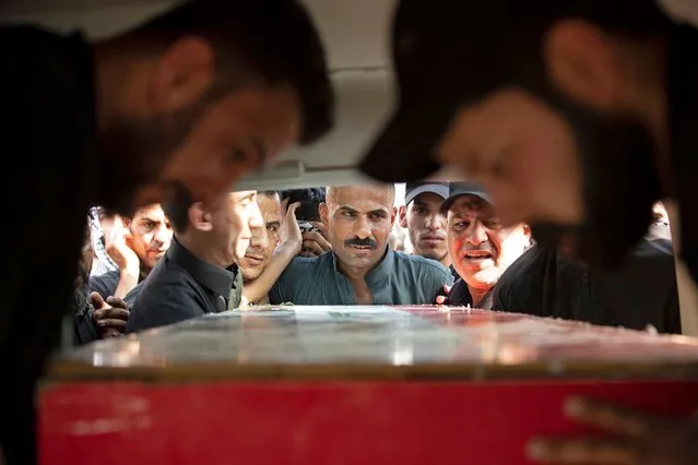 Iraqi mourners attend the funeral of two Saraya al-Salam fighters, an armed faction linked to powerful Shiite cleric Moqtada Sadr, in the southern Iraqi city of Basra on September 1, 2022. Four militants were killed overnight after an ambush in the southern Iraqi city of Basra sparked clashes between rival Shiite factions, a security source, days after deadly clashes in the capital. (Photo by Hussein Faleh/AFP Photo)
