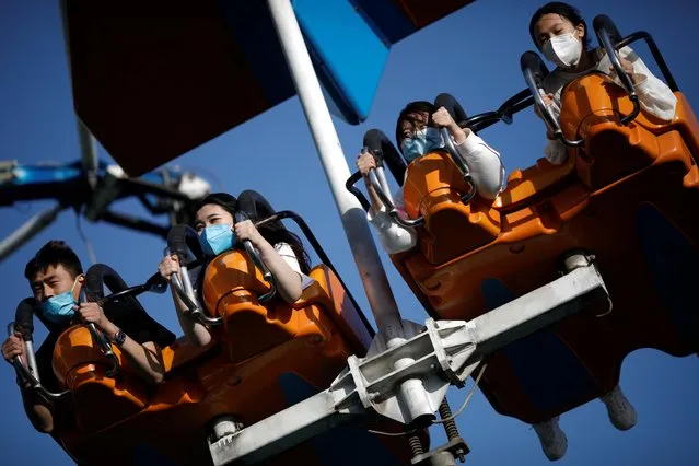 People wearing face masks enjoy an attraction at the Happy Valley amusement park, following an outbreak of the coronavirus disease (COVID-19), in Beijing, China on May 10, 2020. (Photo by Carlos Garcia Rawlins/Reuters)