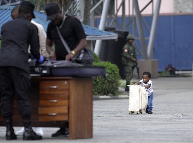 A child pushes a suitcase towards Rwanda security officials checking people crossing from Congo in Gisenyi, Rwanda, Wednesday, January 29, 2025, following M23 rebels' advances into eastern Congo's capital Goma. (Photo by Brian Inganga/AP Photo)