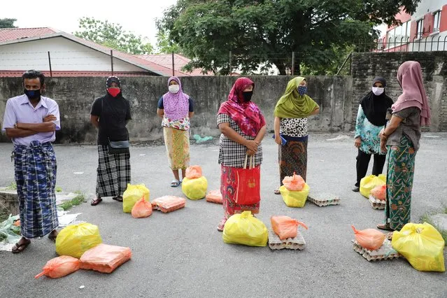 Rohingya refugees wearing protective masks keep a social distance while waiting to receive goods from volunteers, during the movement control order due to the outbreak of the coronavirus disease (COVID-19), in Kuala Lumpur, Malaysia on April 7, 2020. (Photo by Lim Huey Teng/Reuters)
