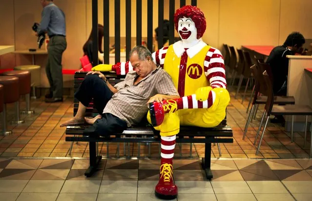 An elderly man takes his afternoon nap at a McDonalds in a shopping mall in Singapore, on October 12, 2012. (Photo by Wong Maye-E/Associated Press)